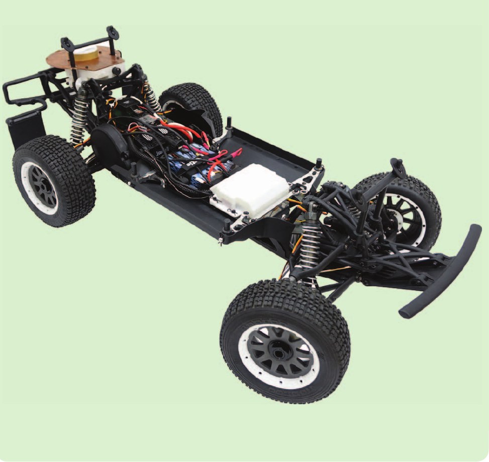 The assembled AutoRally chassis photographed against a pale green background, showing the four wheels, suspension, electronics tray and battery