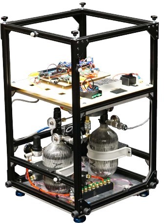 A COSMOS sled: an open aluminium frame carrying electronics on an upper deck and two black compressed-air tanks below, standing on air bearings